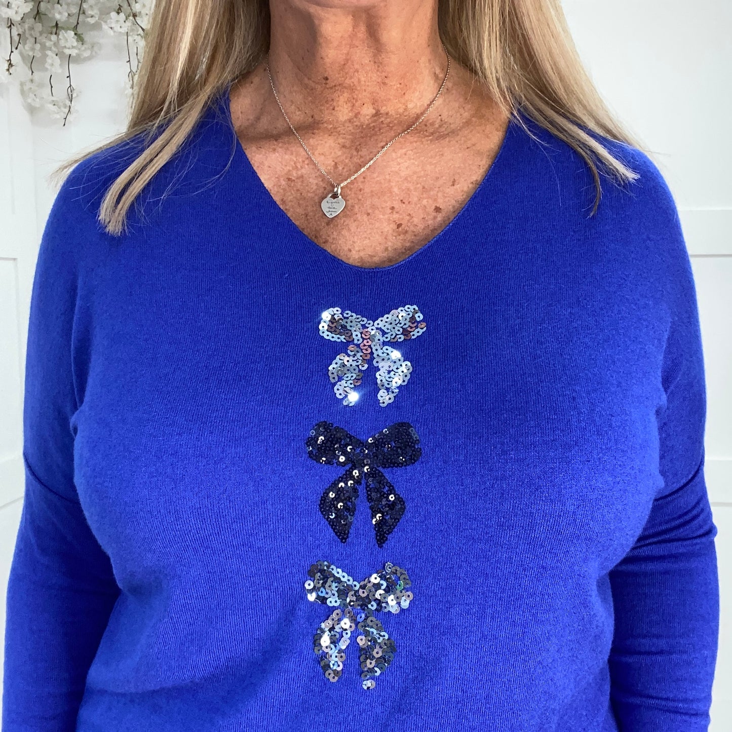 Ellie: Sequin V neck bow top. One size: 12-18